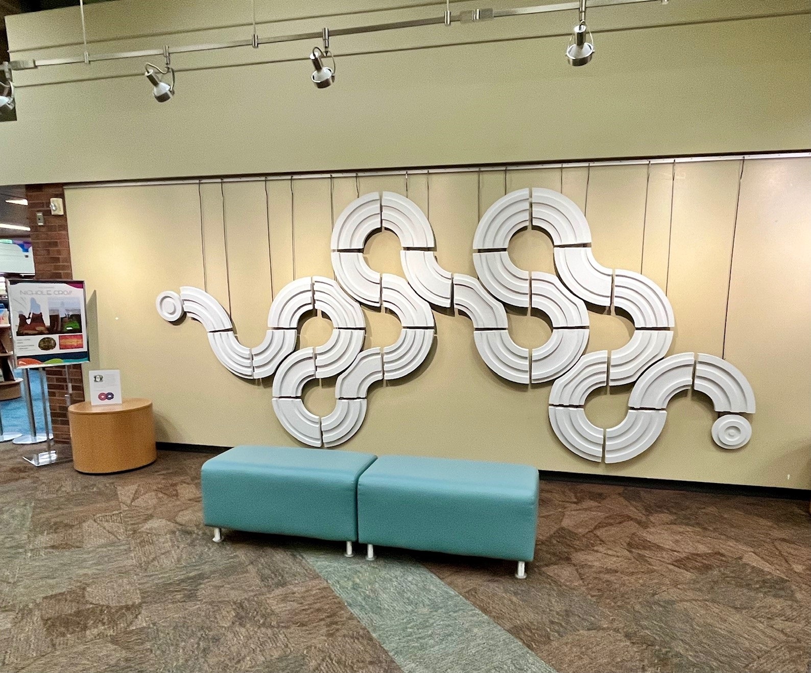 Abstract, serpentine artwork by Nichole Cross hanging at the Downtown Library.