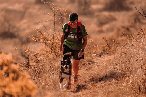 woman and dog hiking on a trail