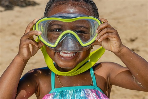 little girl smiling with scuba goggles