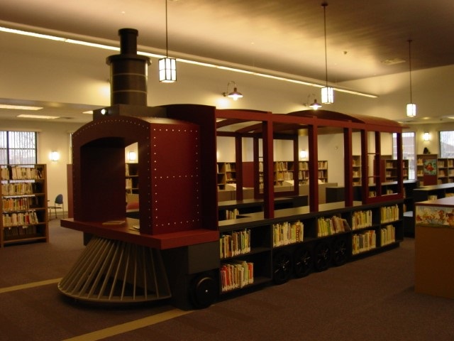 Life-sized, train-shaped book shelving unit inside the Caille Branch Library