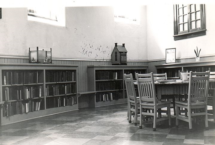 Bookshelves and a table in the children's area in the Carnegie Free Public Library